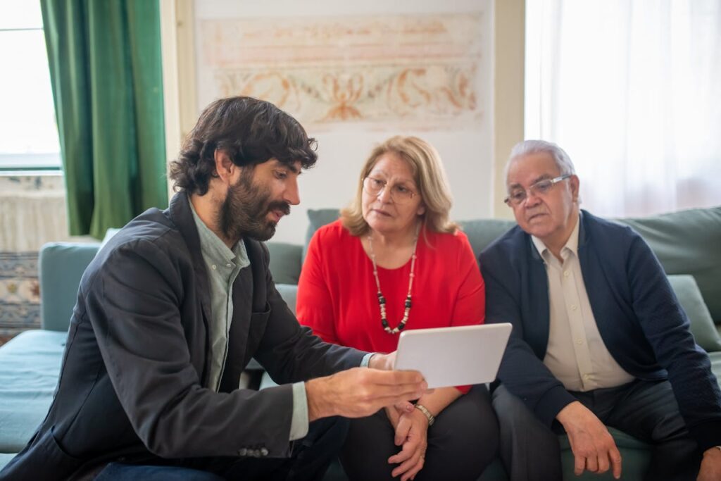 A financial advisor discussing investment options with an elderly couple in a cozy living room.